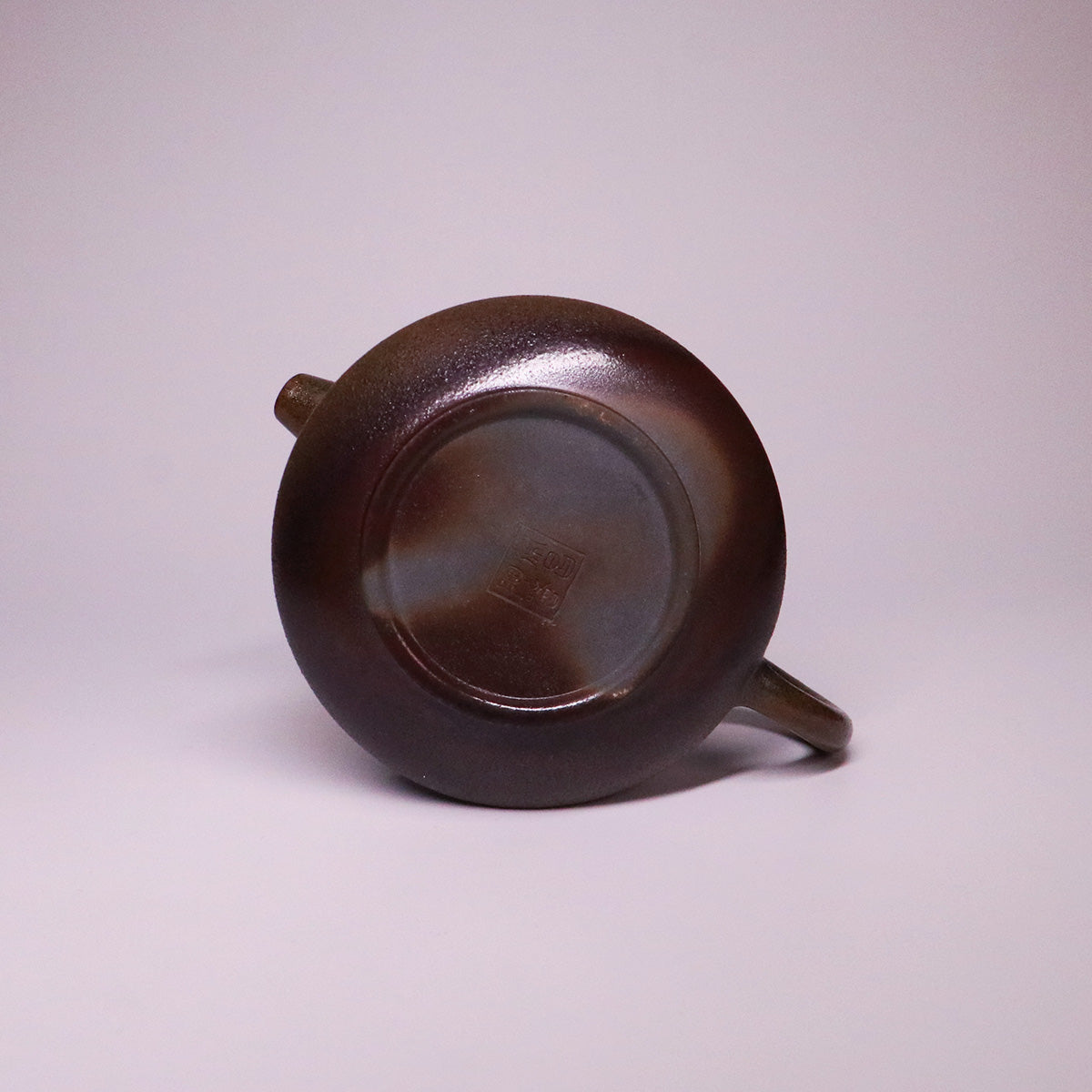 Bottom view of artisan Rongchang Chinese pottery teapot showcasing handmade dark brown ceramic texture