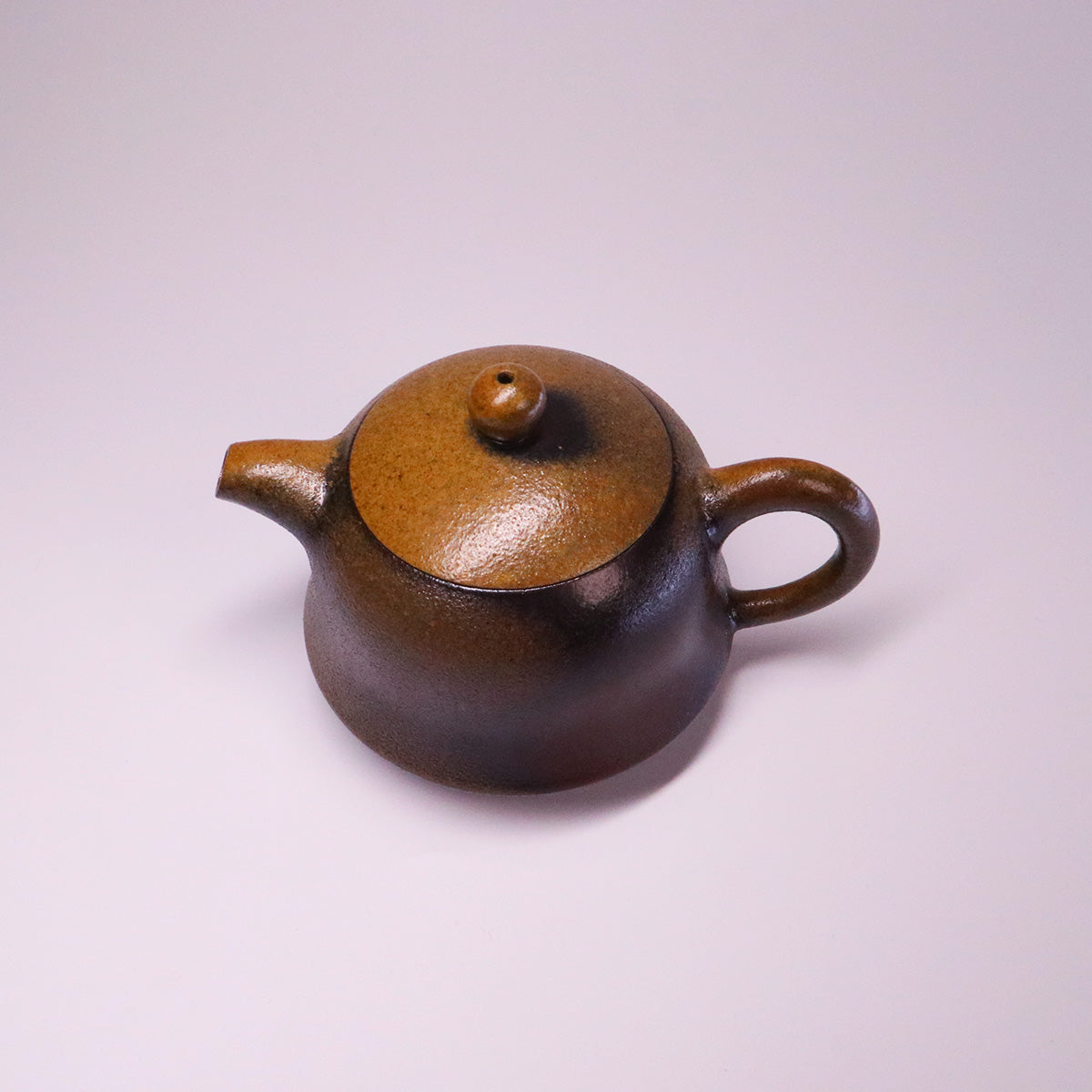 Artisan Rongchang Chinese pottery teapot in brown handmade ceramic with round shape and curved handle
