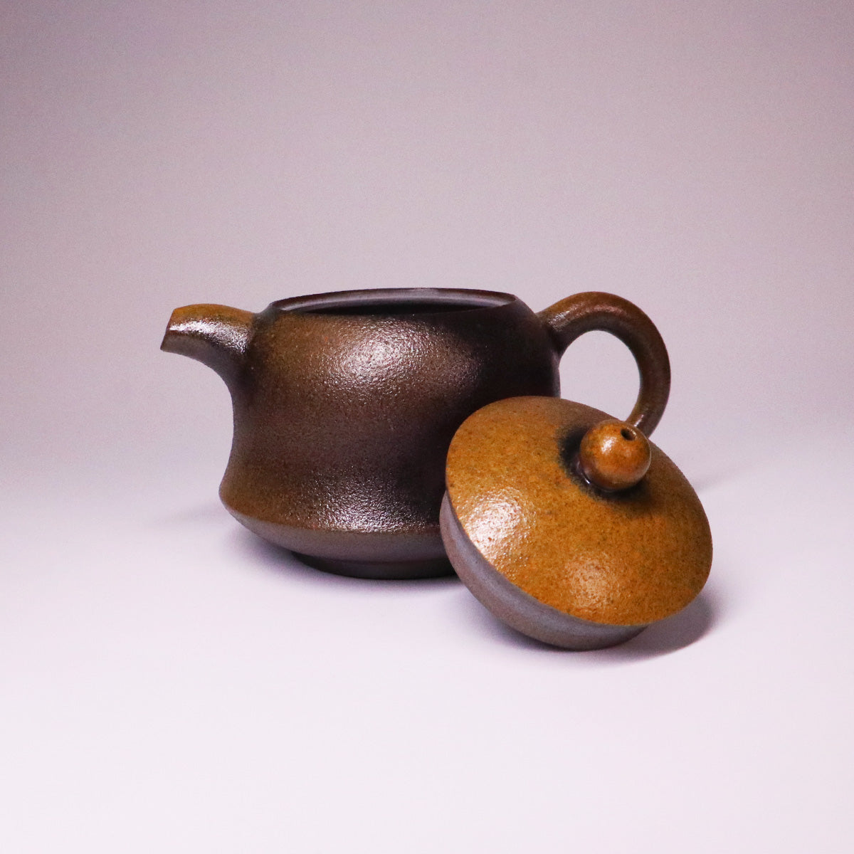 Artisan Rongchang Chinese pottery teapot with a textured dark brown body and separate lid