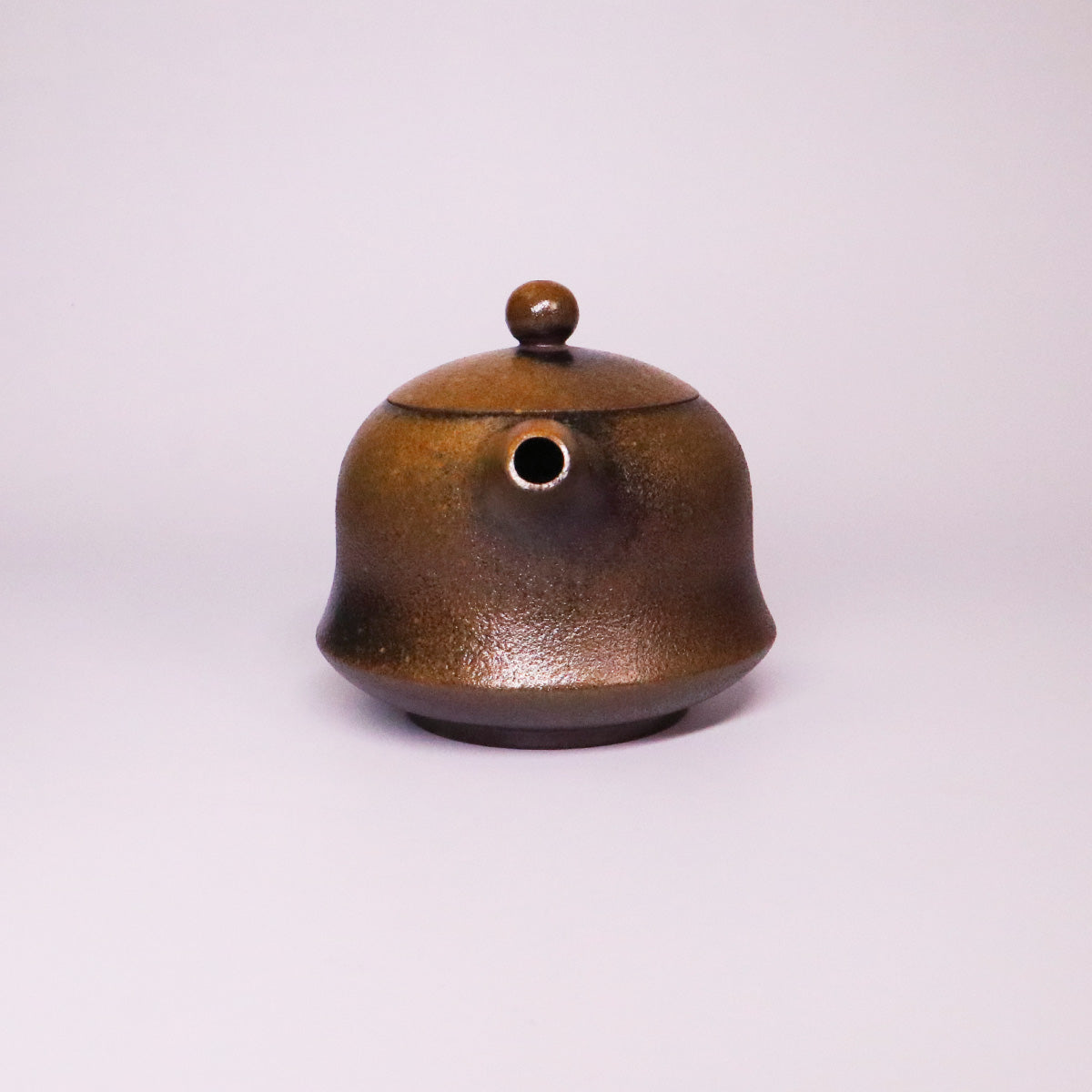 Handcerami artisan Rongchang Chinese pottery teapot in brown with a round lid and spout on white background