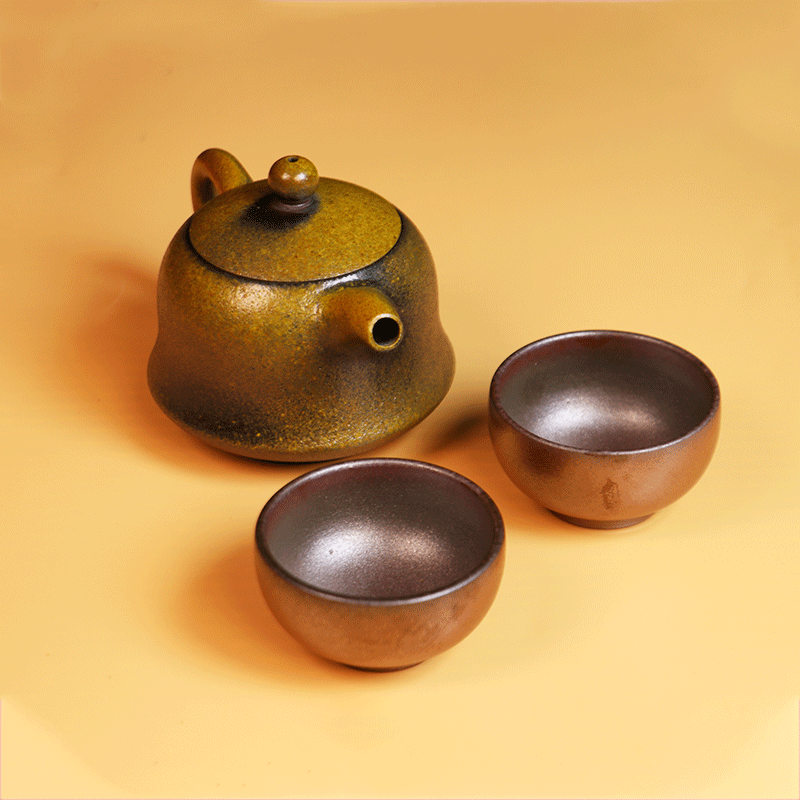 Artisan Rongchang Chinese pottery teapot with two matching ceramic tea cups on a light background