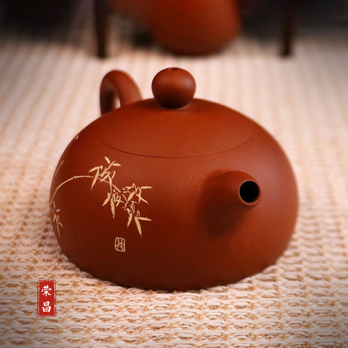 Handcerami handcrafted ceramic teapot in brown with delicate bamboo design on woven surface